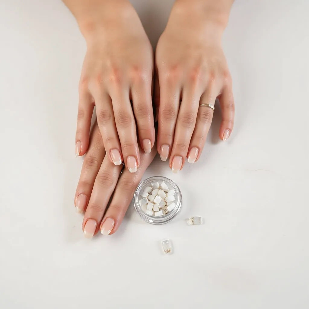 Hands with neatly applied reusable press-on nails beside a small container of press-on nail tips