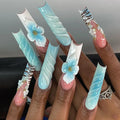 Nails with decorative designs featuring flowers and patterns on a neutral background