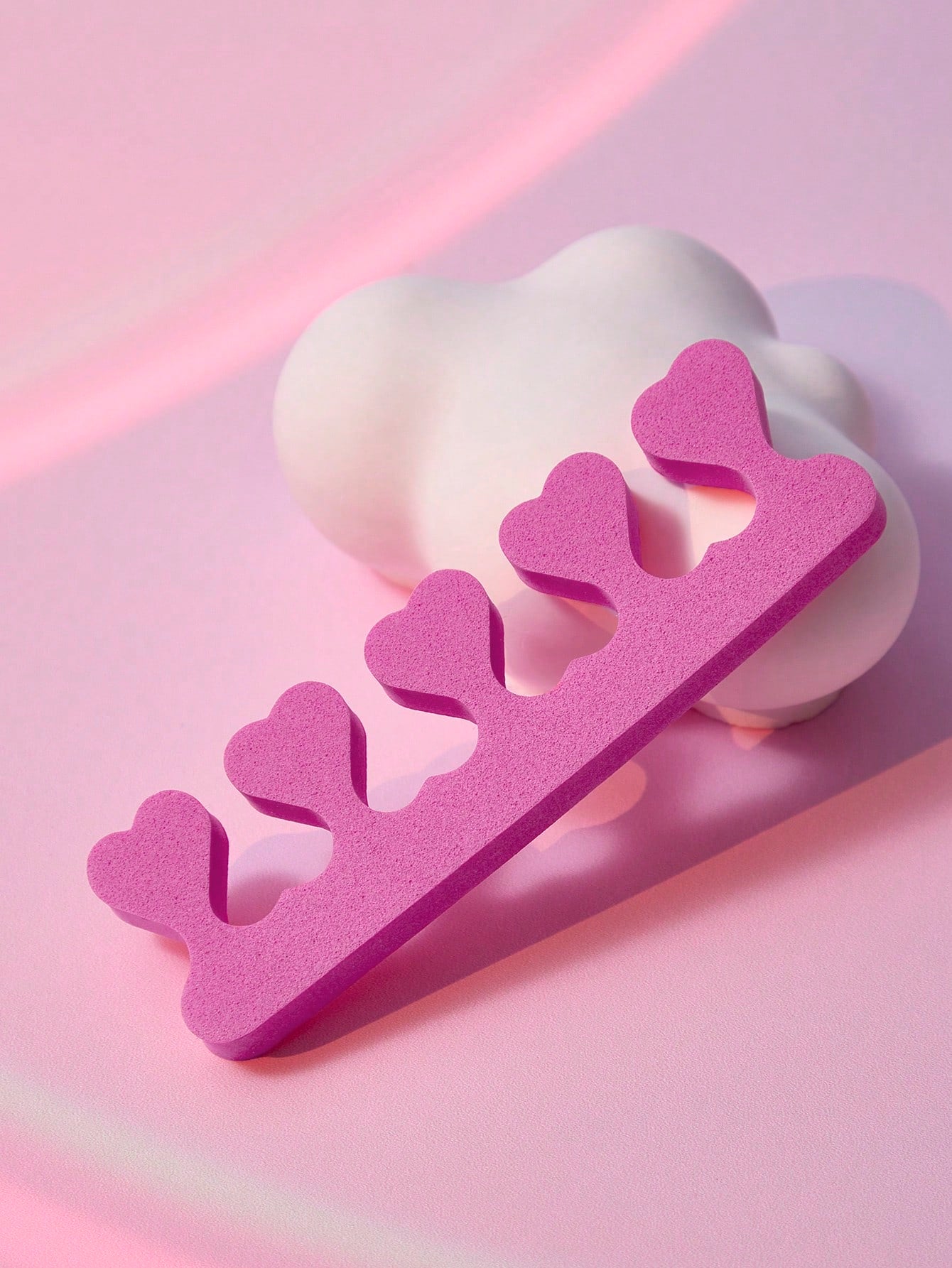 Pink nail cuticle pusher on a pink background
