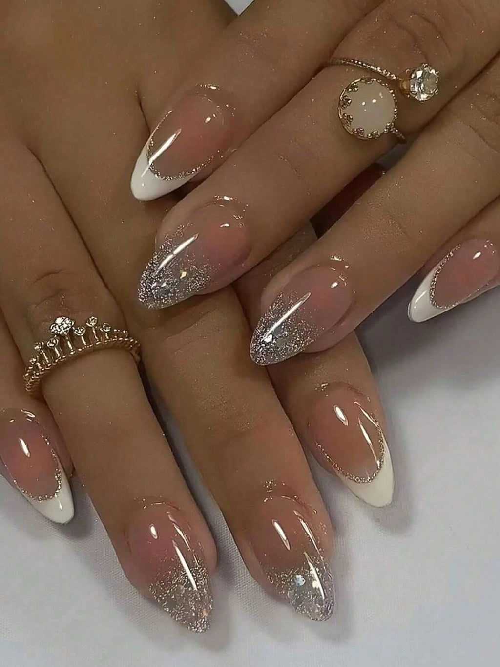 Nails with pink and silver glitter design on a white background