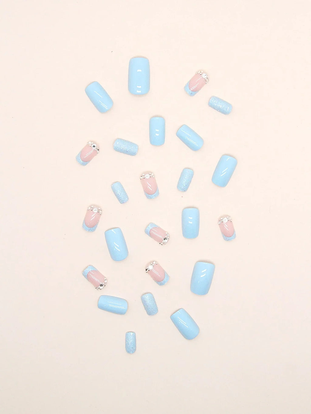 Pastel blue and pink nail polish bottles scattered on a light pink background
