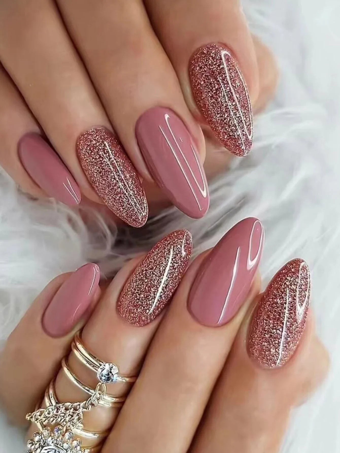 Close-up of hands with pink and glittery nails on a white background