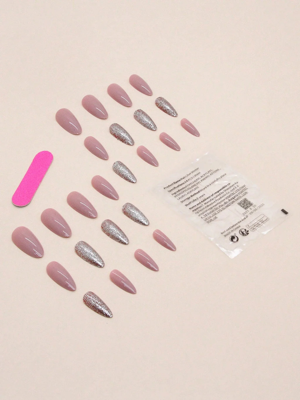 Set of pink and silver nail extensions with a clear plastic bag on a beige background