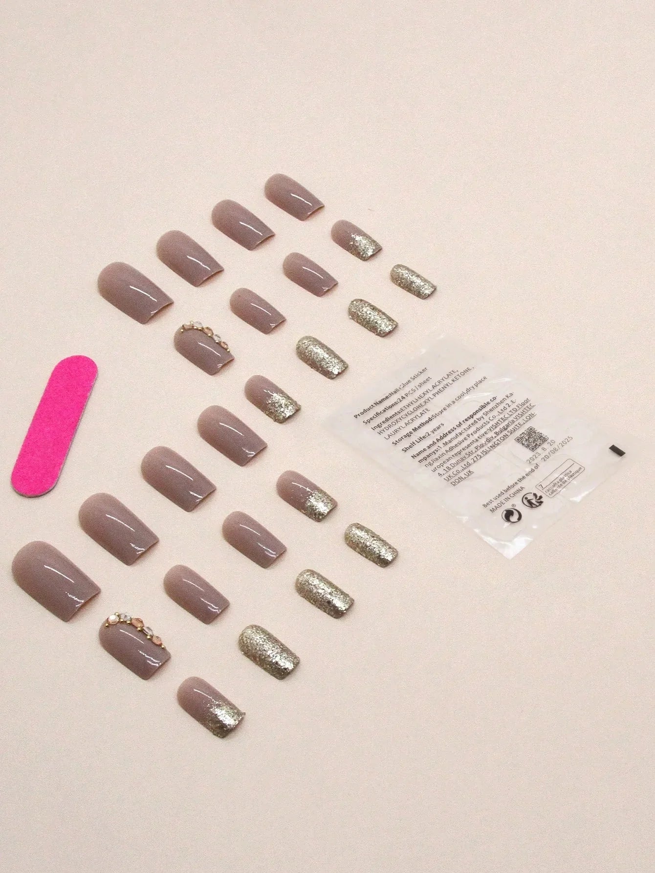 Set of press-on nails with glittery accents on a beige background