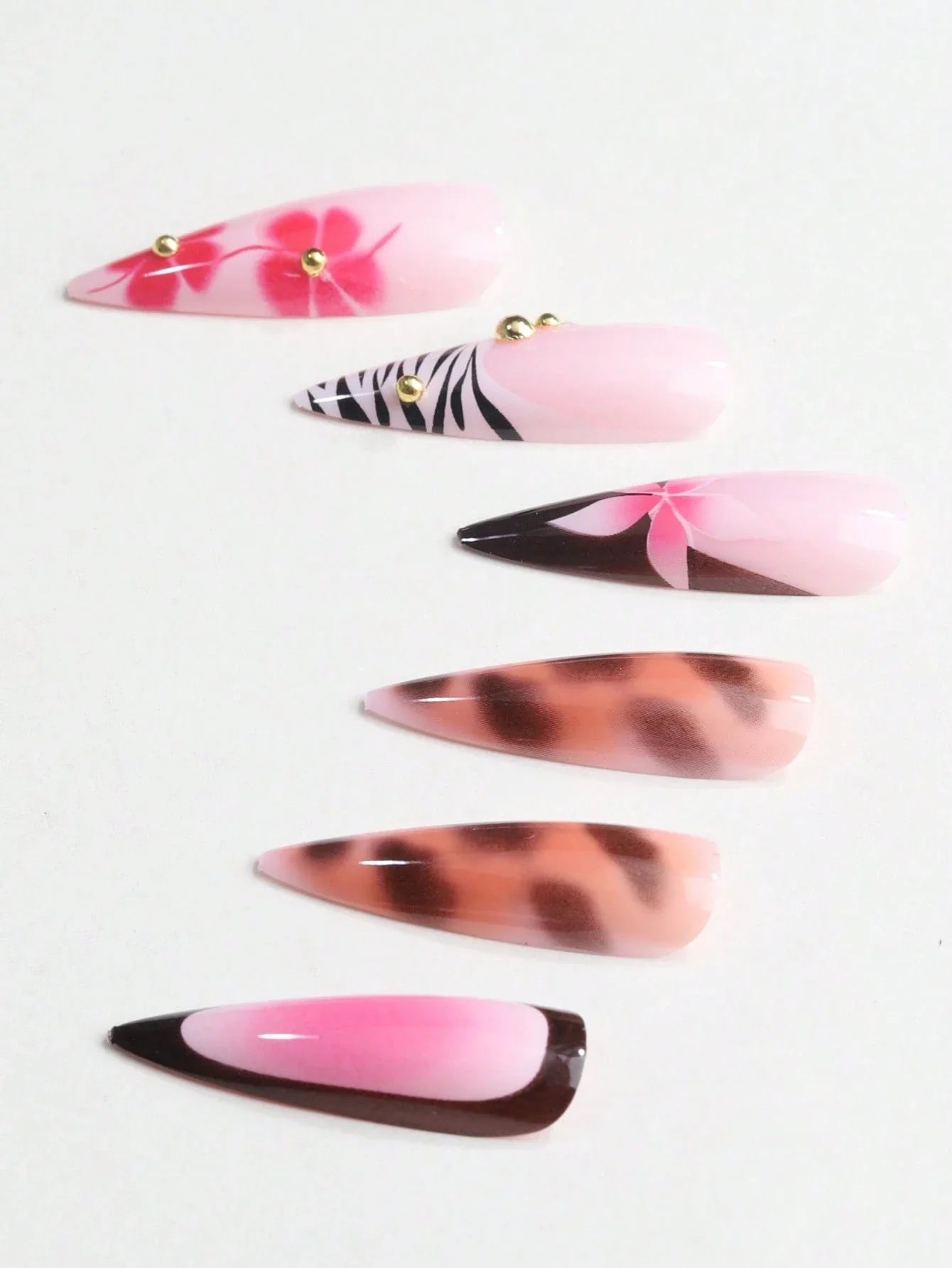 Set of false nails with various designs on a white background