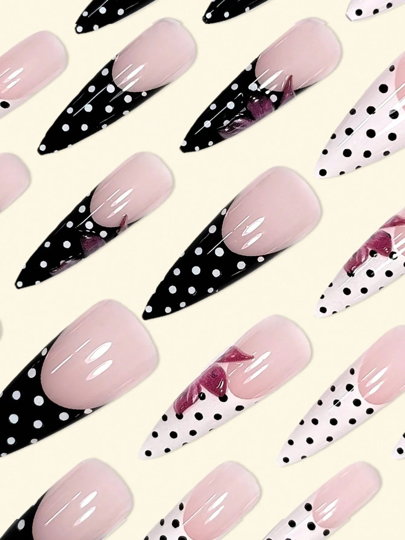 Nail art with pink and black polka dot designs on a light background