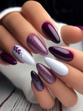 Nails with a gradient design transitioning from purple to white on a neutral background