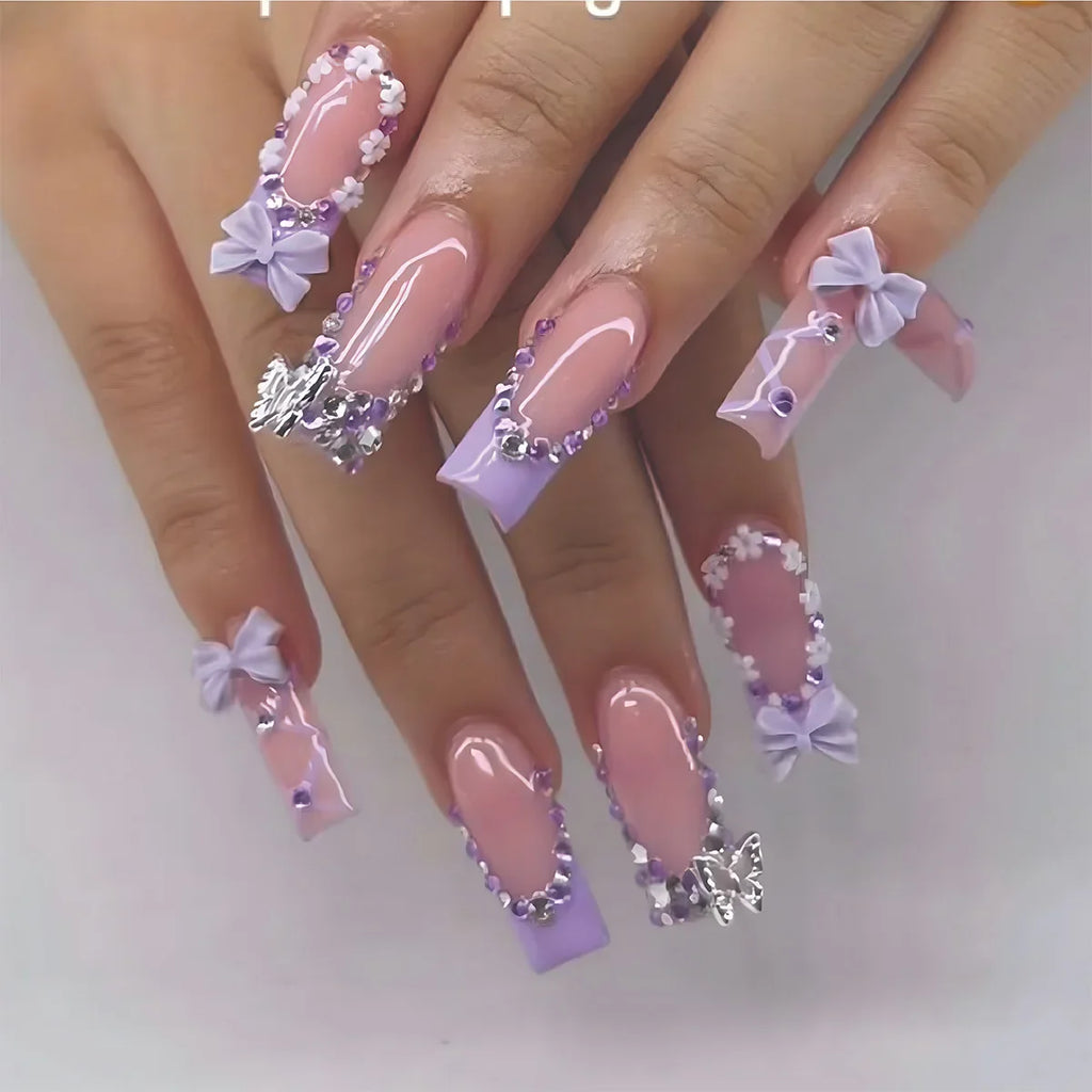 Nails with decorative bows and rhinestones on a white background
