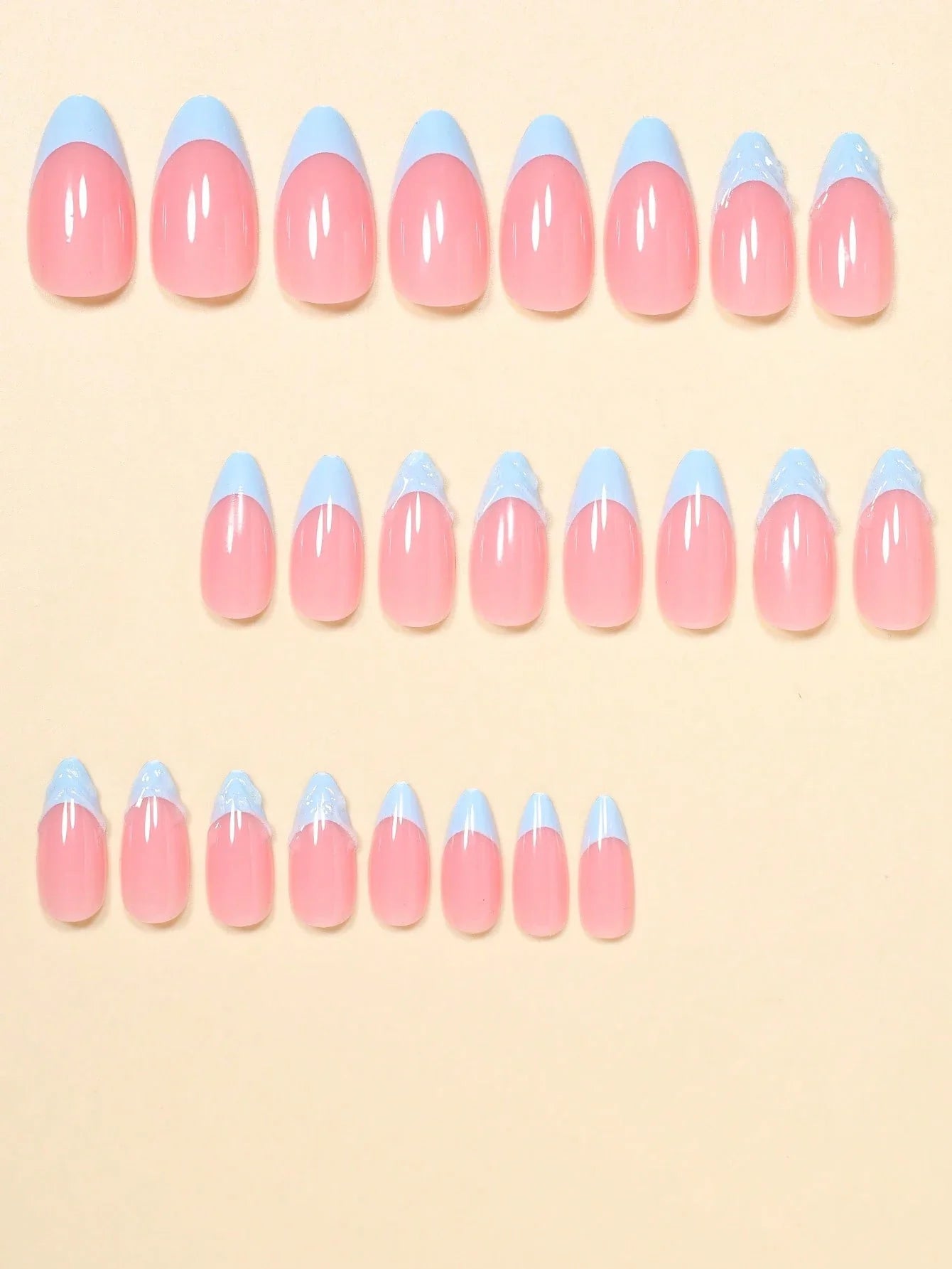Set of pink and blue nail art designs on a beige background